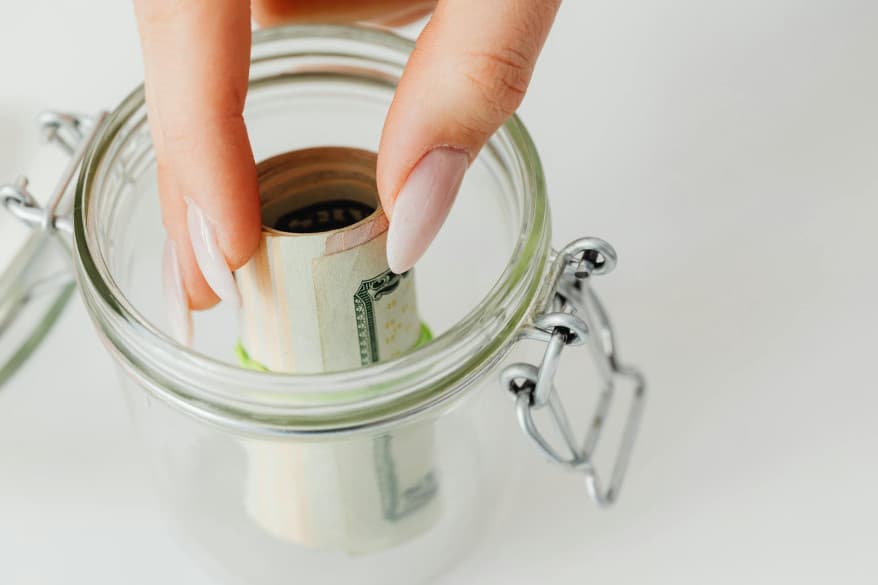 Person placing money in jar