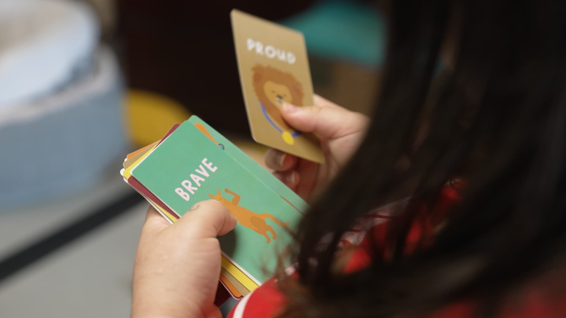 Student at Hoffman Academy holding BRAVE and PROUD character cards
